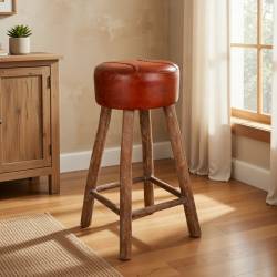 TABURETE DE MADERA CON ASIENTO EN POLIPIEL EN UNA HABITACION DE HOTEL RUSTICO